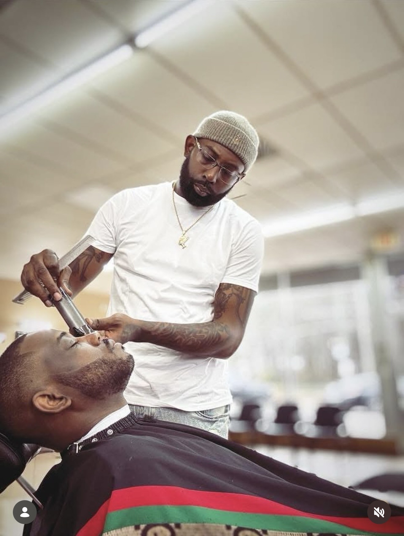 Barber at Headlines Barbershop lining up a client's beard